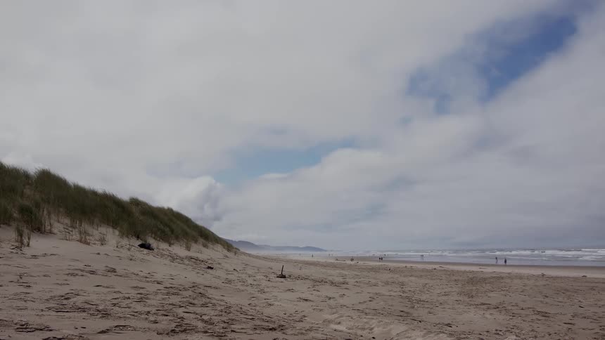View of a beach with extensive sand on a blue sky day with clouds