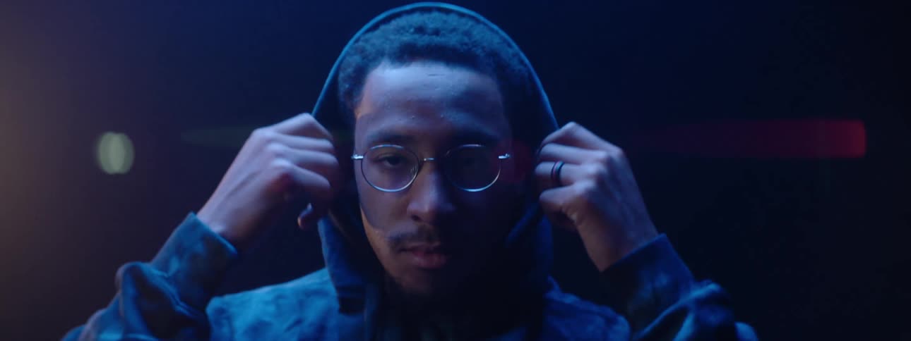 Man wearing a filmmaker hoodie adjusts the hood around his face