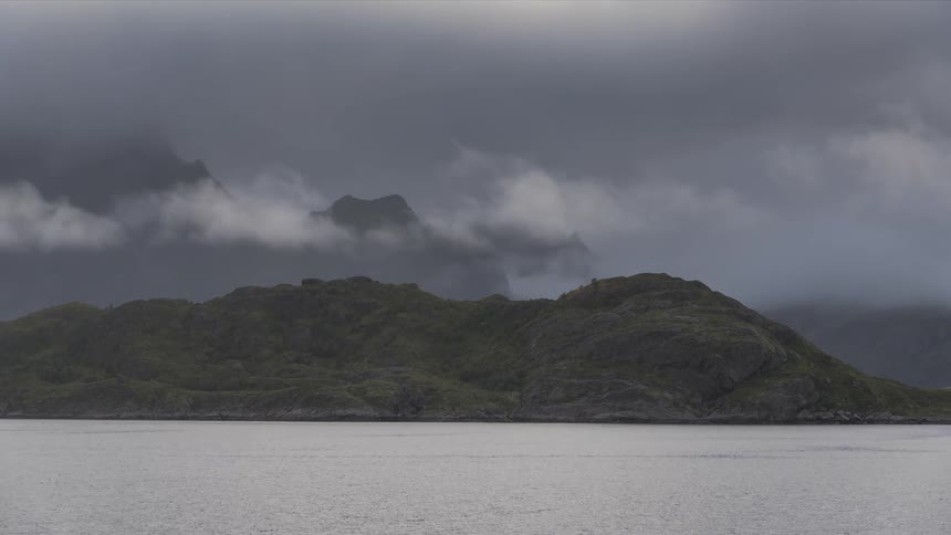 During dawn on a cloudy evening near a river bank there is a mountain