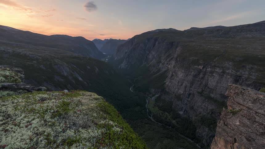 Shadows creep over a mountain and canyon