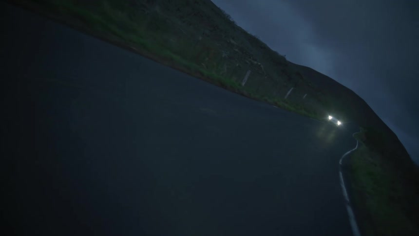 A car drives down a road at night