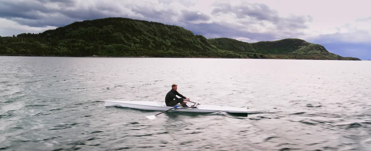 Man rows in solitude showing athletic discipline and mental focus