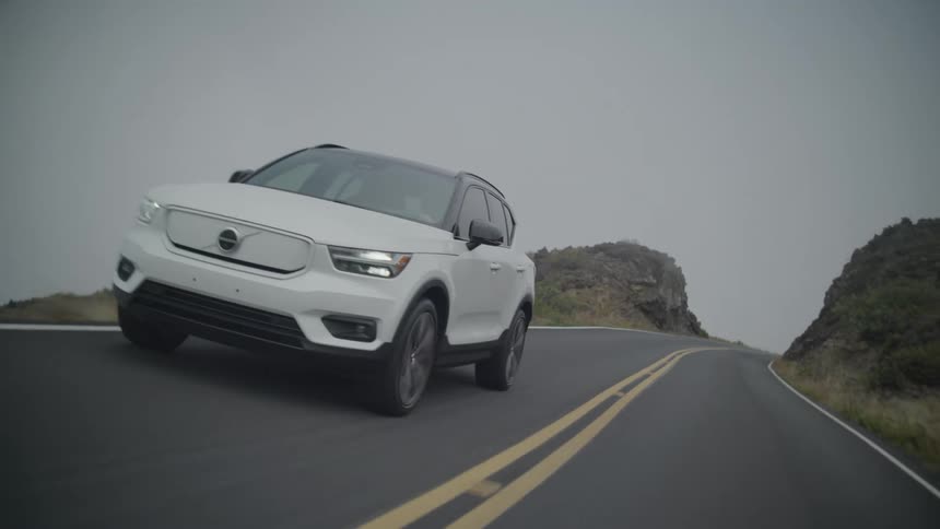 Pearl white suv vehicle traveling down a road on a cloudy day