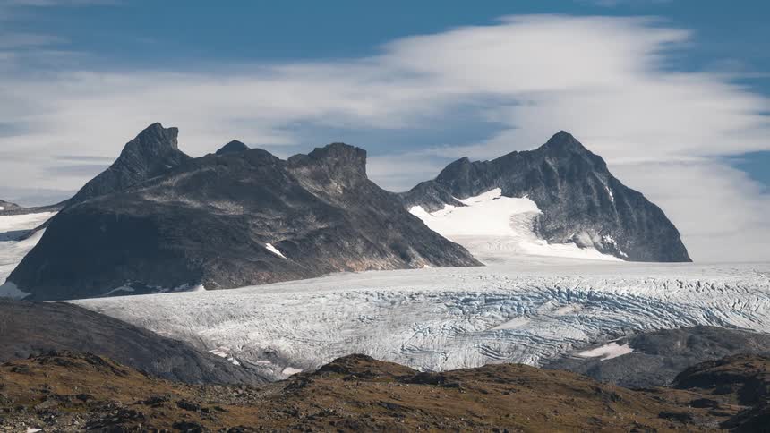 Landscape with snow covered mountains and clouds passing by in team labs
