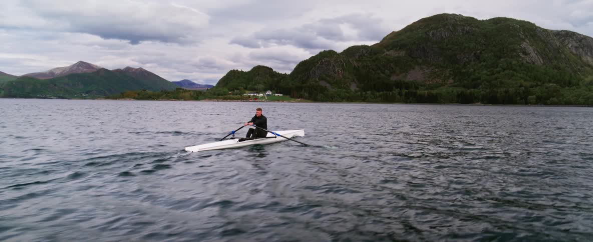 A man rowing a rowboat on the sea during the day