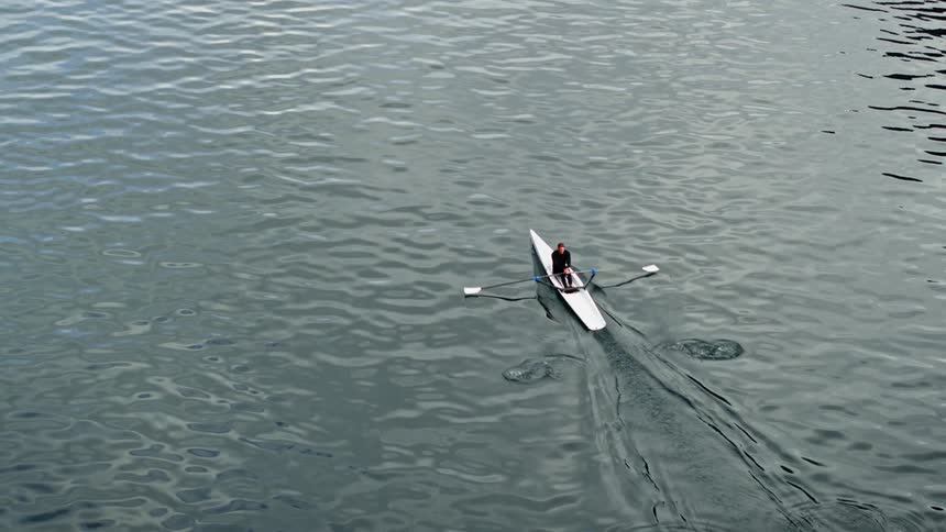 Man rowing in a calm sea with a meditative feel