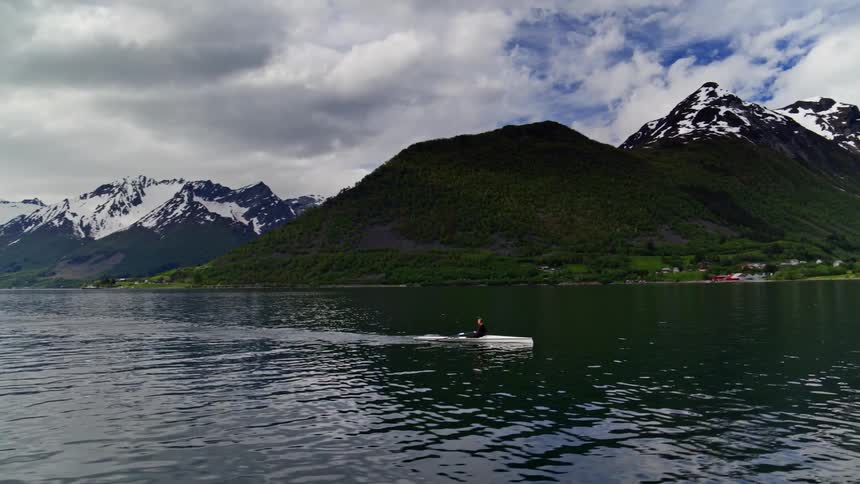Daily practice regimen featuring a rower out on the placid water with a moody sky