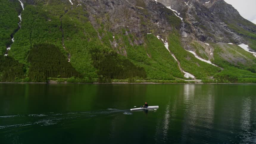 Dynamic aerial of an athlete training on the water surrounded by epic scenery