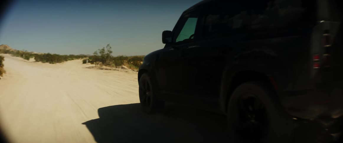 Black jeep traveling on a desert dirt road during the day