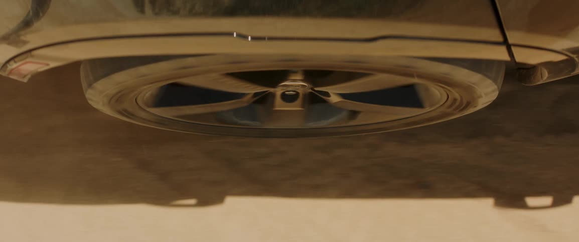 A car wheel rolling on desert sand