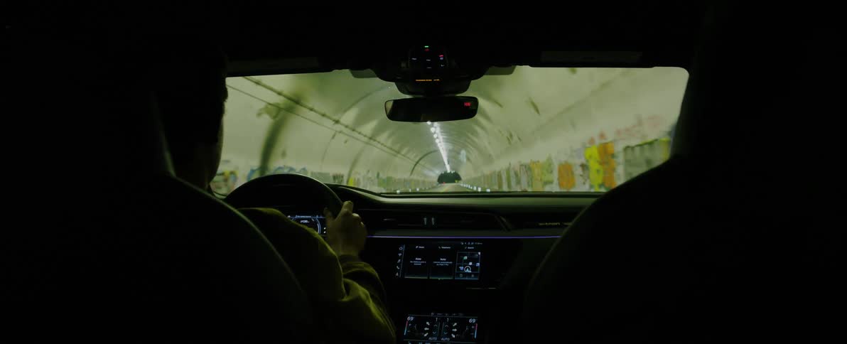 A man driving a car in a tunnel in the city at night