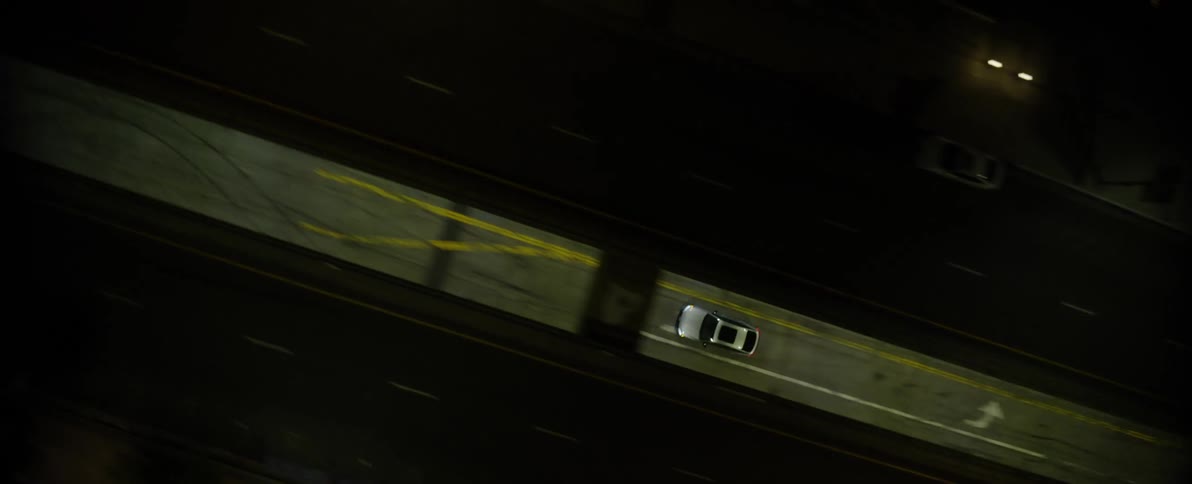 Lone vehicle drives empty city streets at night