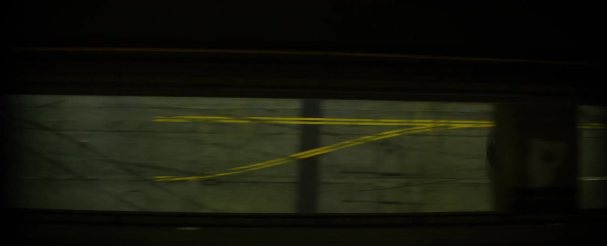 A vehicle drives along a city street which has a number of skid marks on it
