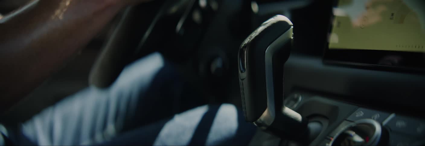 A man shifts gears in a car