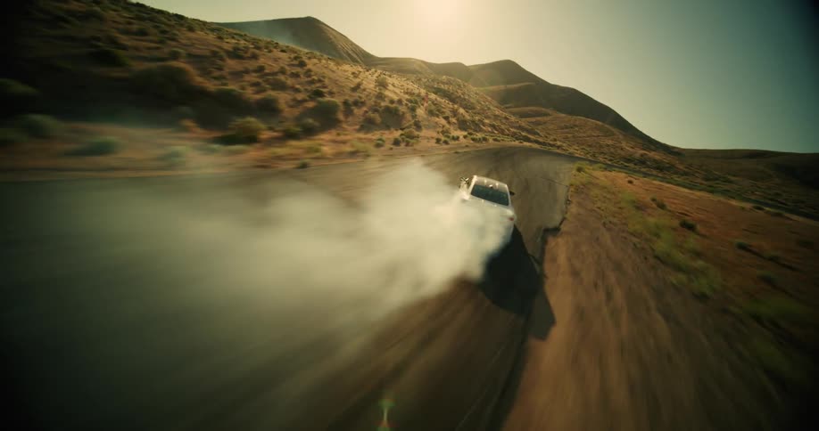White colored sports bmw making turns along a road in a desert location