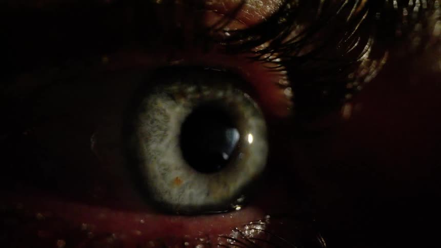 Closeup of a persons dilated pupil in a dark environment