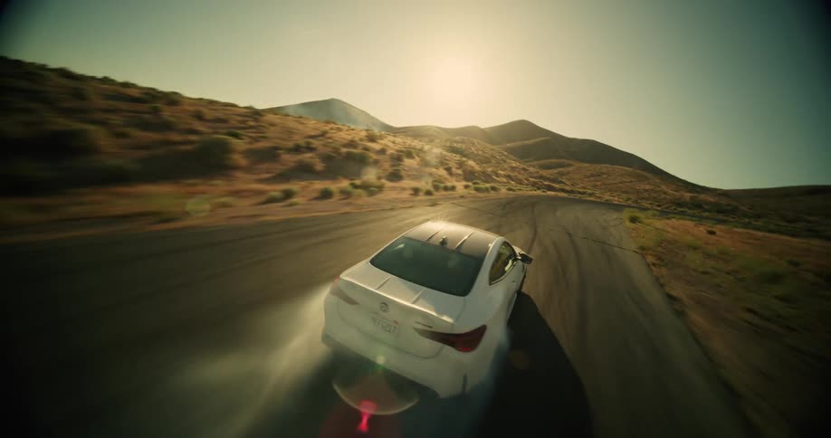 A white car drifting on an asphalt street in a desert region