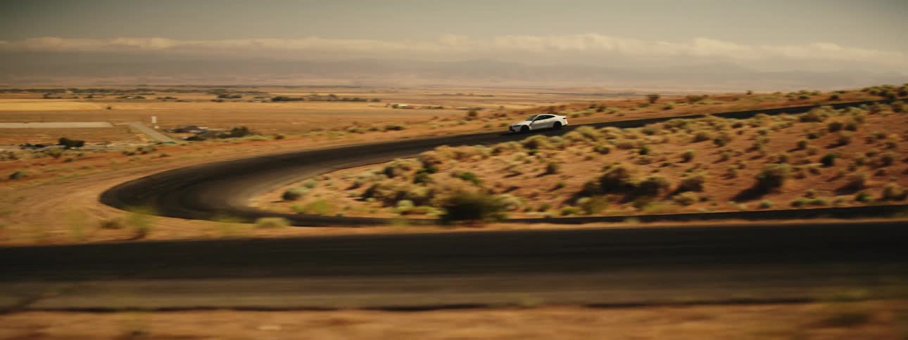 Bmw sports car making curves on a road and a natural desert location