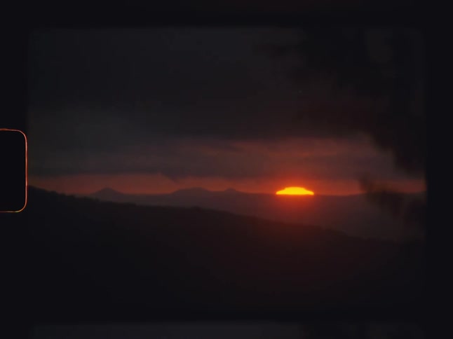 Natural landscape of hills and mountains with the red sun rising on the horizon