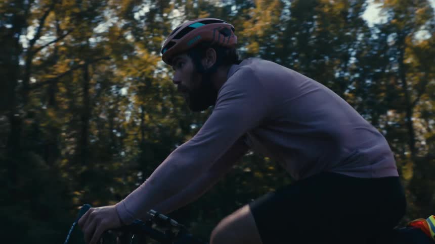 A man cycling on the road in the middle of the day
