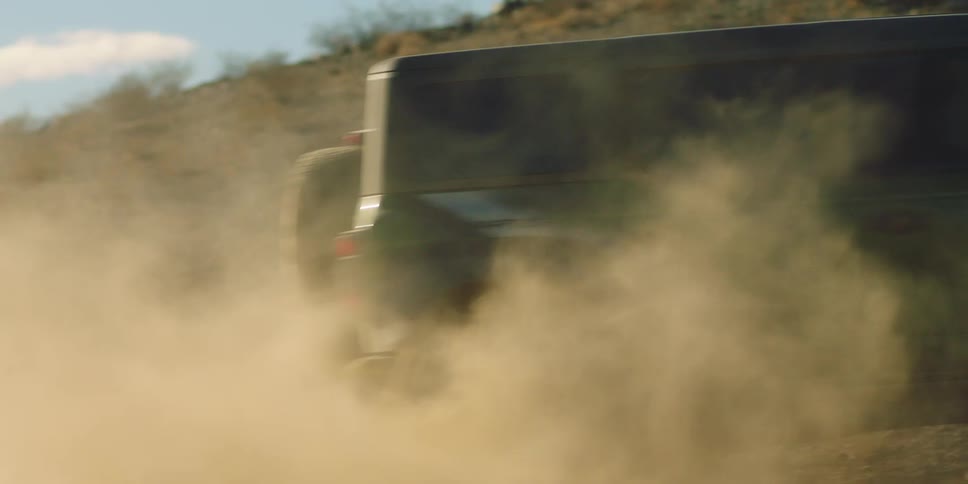 Black jeep speeding up a hill in a desert location