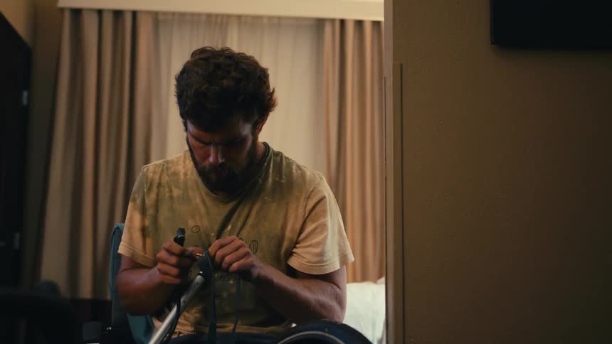 A man sitting in his room inflating a bicycle tire