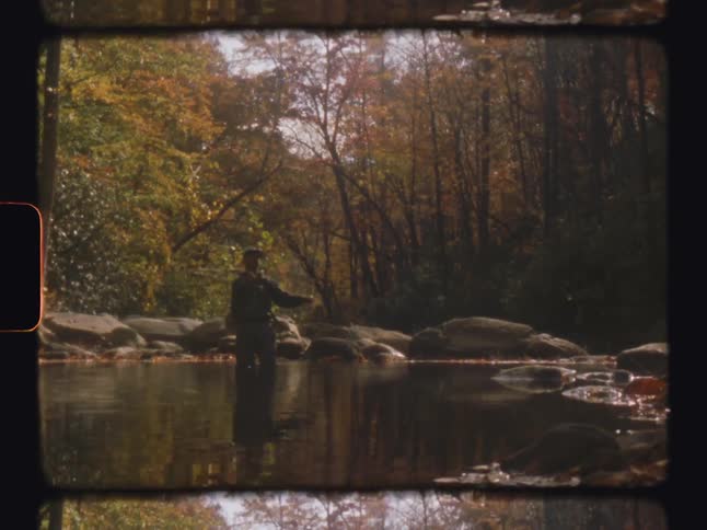 Man in a lake casting his fishing rod