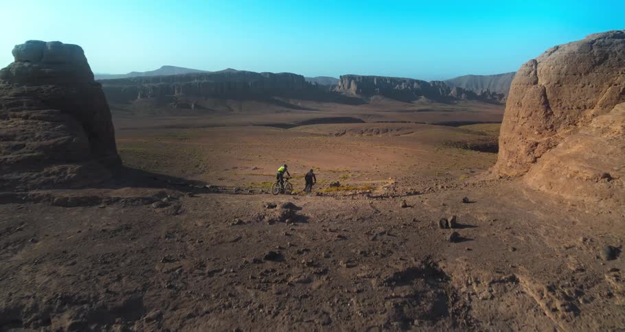 People on bicycles compete in mountain biking on a mountain during the day