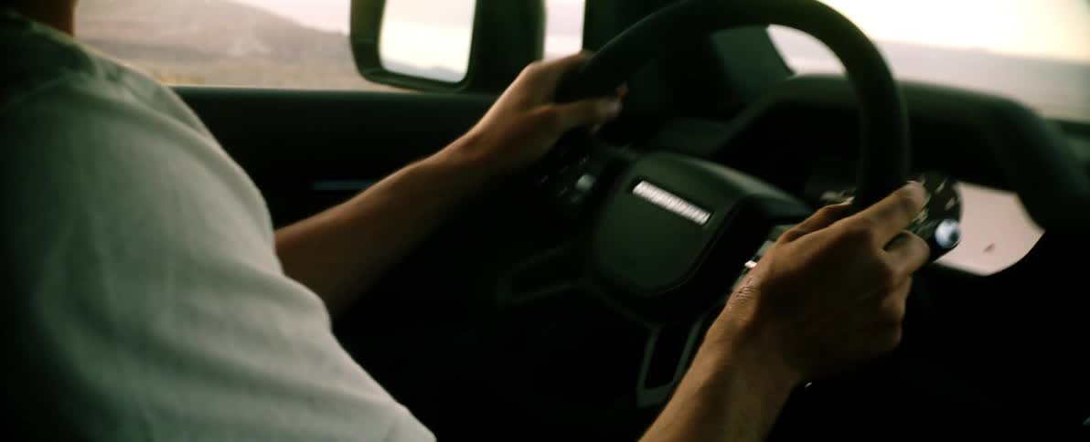 Closeup on the hands of a person driving a vehicle on a dirt road natural environment