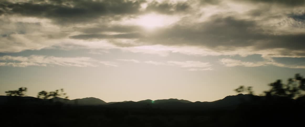 Clouds cover the sun over the mountains
