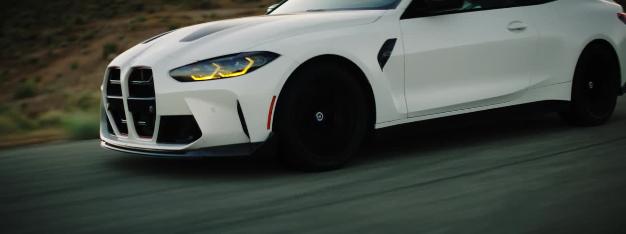 A white sport car driving in a lonely road in the valley
