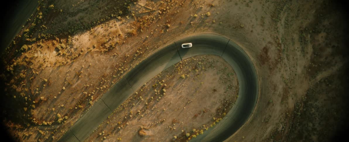 A car doing a tight curve on a desert road