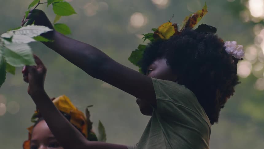 Two children play with flowers in the forest