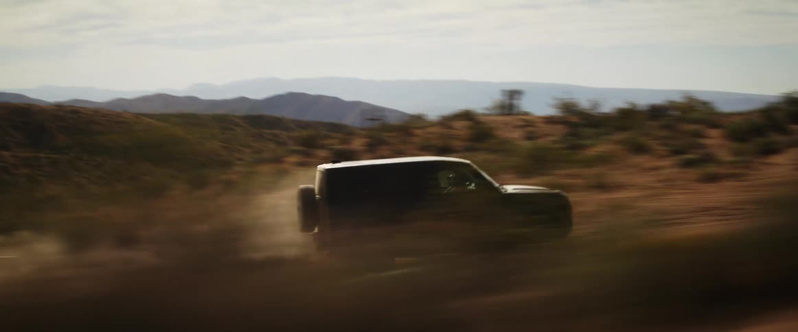 A car driving at high speed on a road in the hills