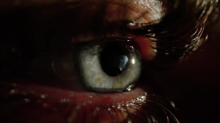 Close up of a human eye with a light turning on and off