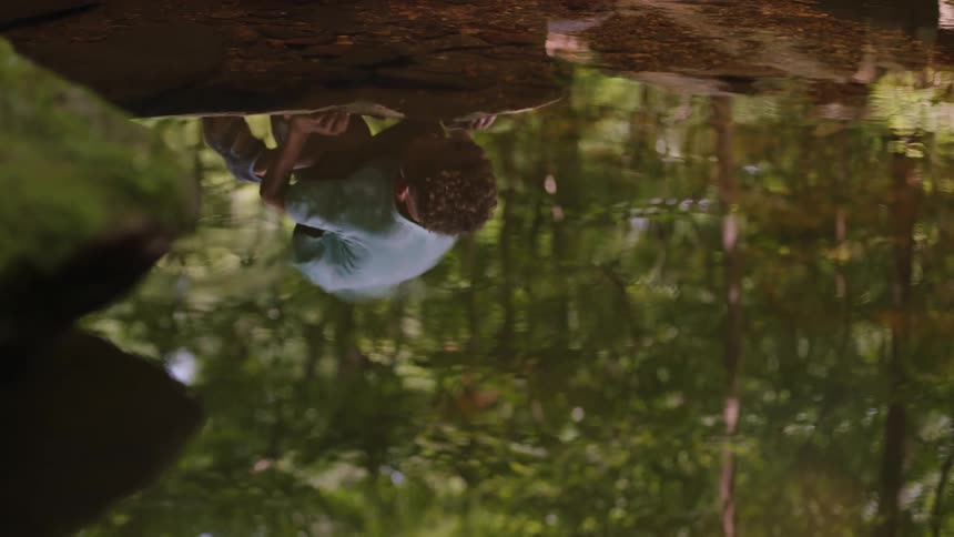 A child near a stream in the woods