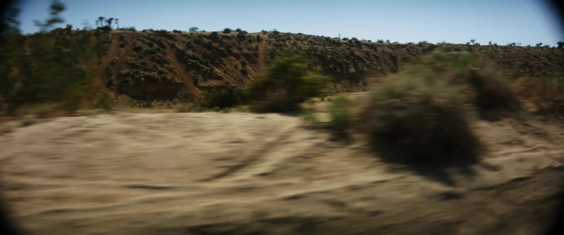 A vehicle leaves a dust cloud driving off road