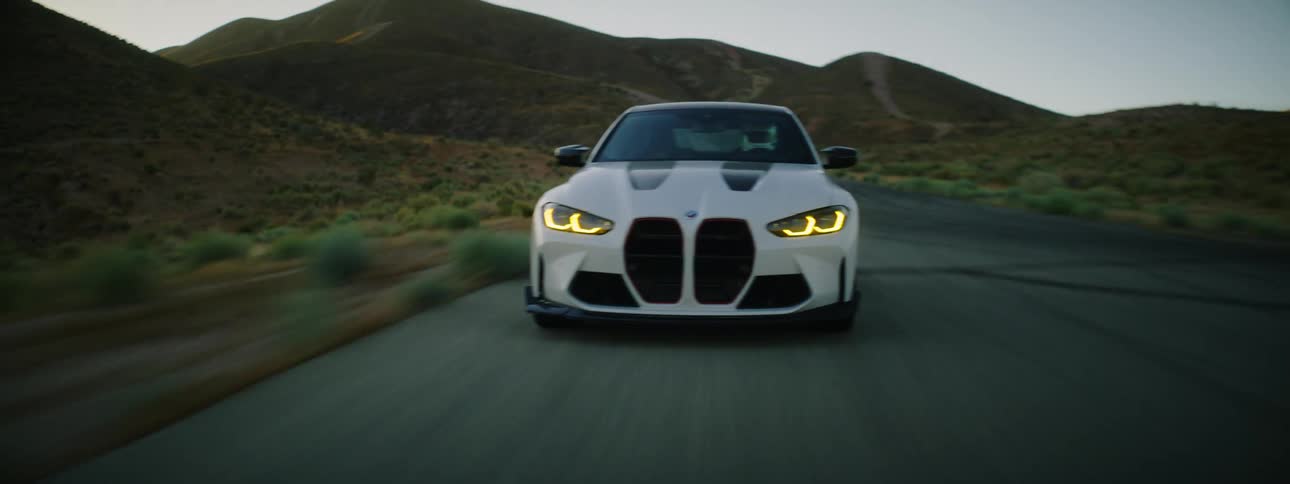 A car takes a turn on a road in a desert