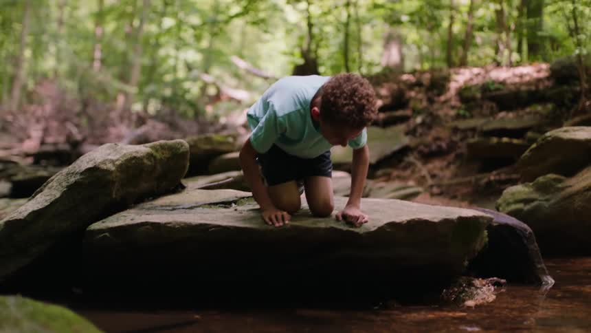 A child looks at his reflection in the water