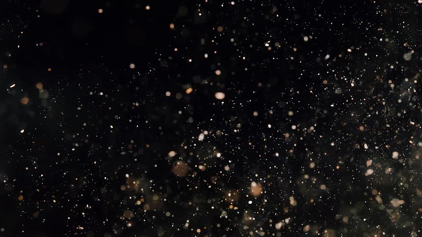 Small sparkly particles floating over a dark background