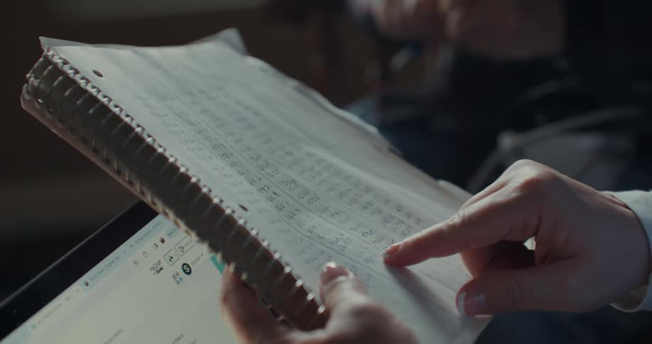 A person points to notes in his notebook