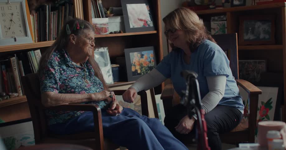A doctor and a patient interact in an environment full of objects including works of art and books