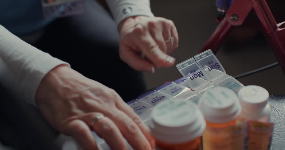 A female care worker fills a weekly prescription for her patient