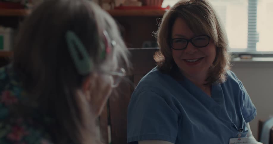A nurse talking to an elderly patient at home