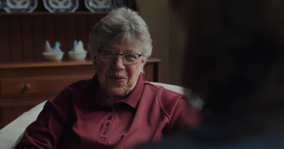A clip of an elderly lady smiling and having a conversation