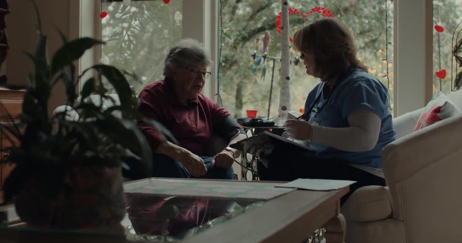 A nurse talks to a patient in a room