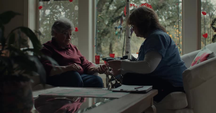 A nurse is giving aid to a woman at home