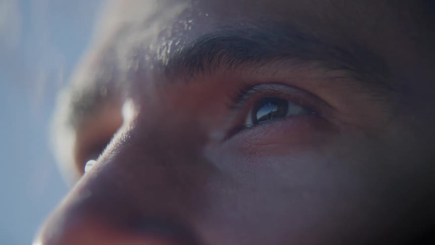 A closeup of a persons eye with the sky reflected in it