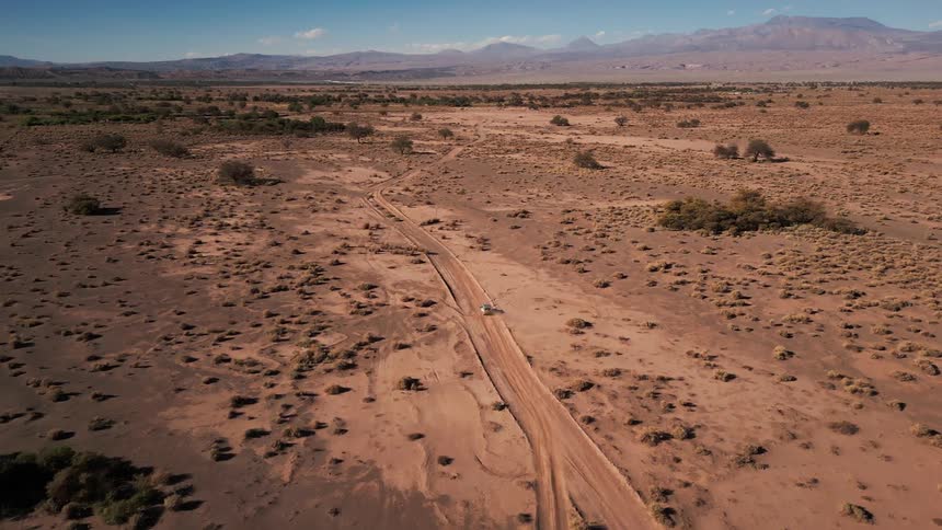 A car drives on a road in a desert