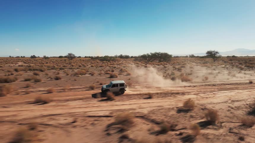A jeep dives down desert dirt road